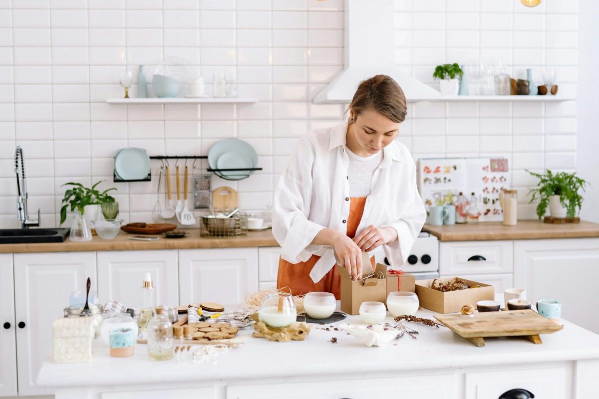 A young woman chef cooks in a stylish kitchen with bright lighting and elegant decor.